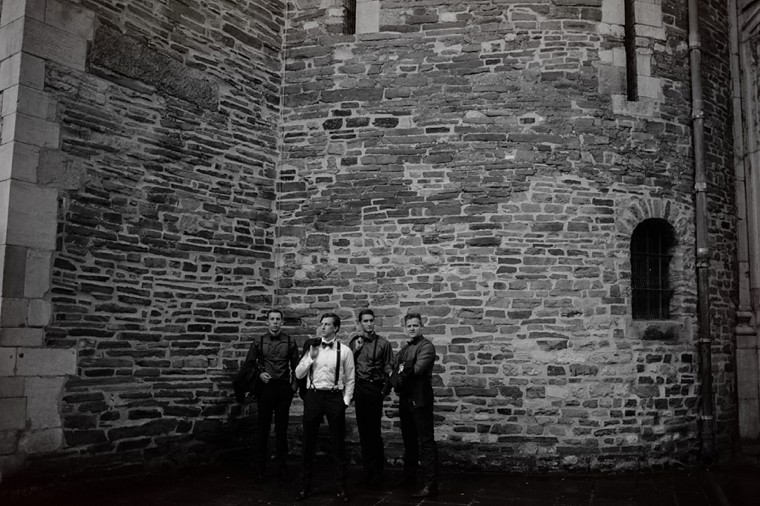 groomsmen portrait in front of european castle